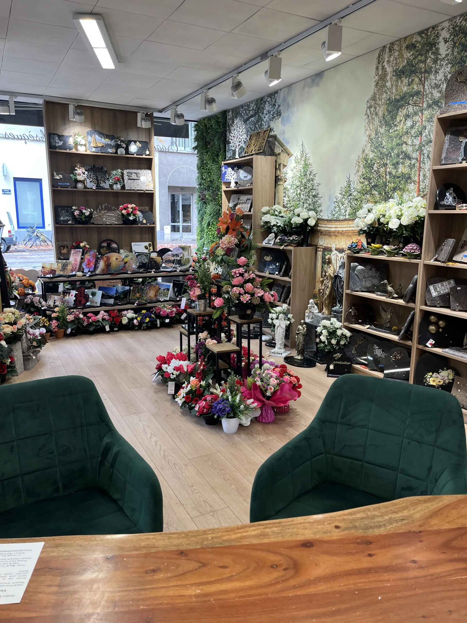 Intérieur d'un magasin de marbrerie funéraire avec articles de souvenir et fauteuils en velours vert