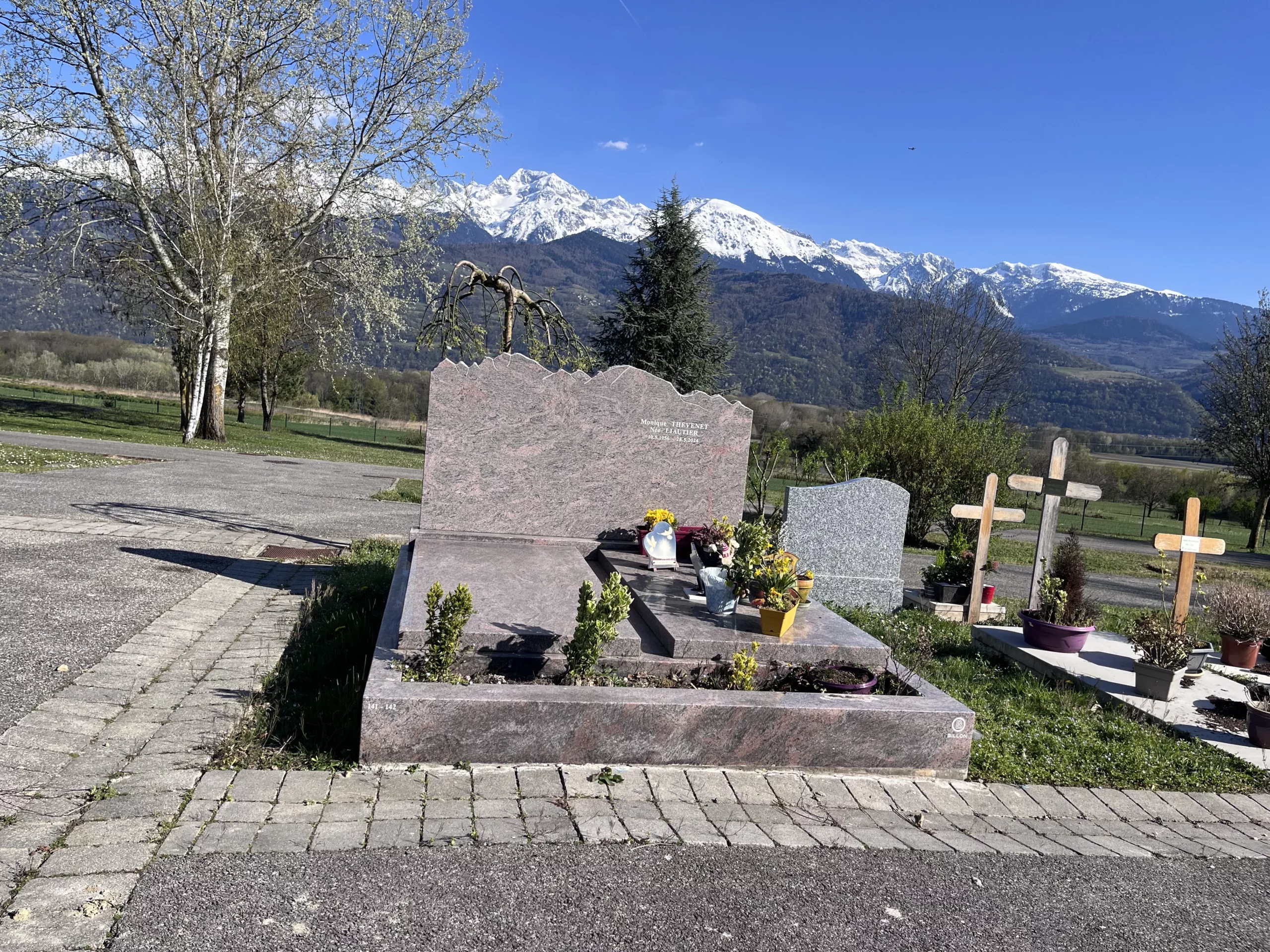 Monument funéraire en granit érigé dans un cimetière paysager